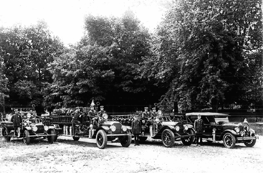 P15 The Needham Fleet c1930 Dick Salamone on running board far left, 3rd truck from left Walter Mullin, Leo Brady.png